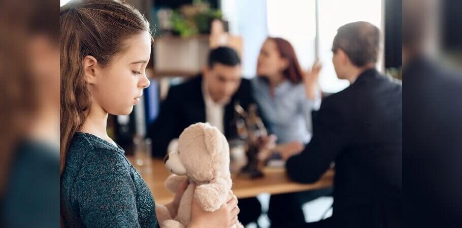 Child sadly looking down while her parents argue