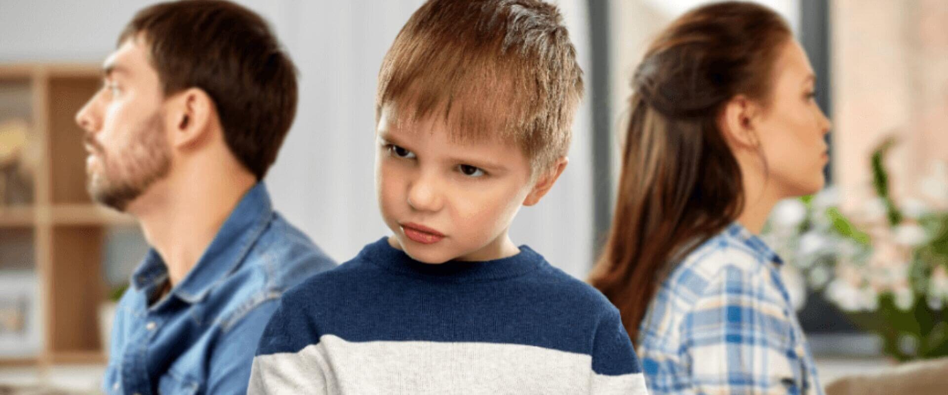 boy with a frustrated pouty face and his parents are in the background