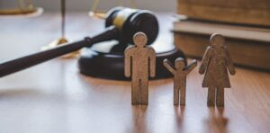 image of small cardboard cutout family and gavel in background