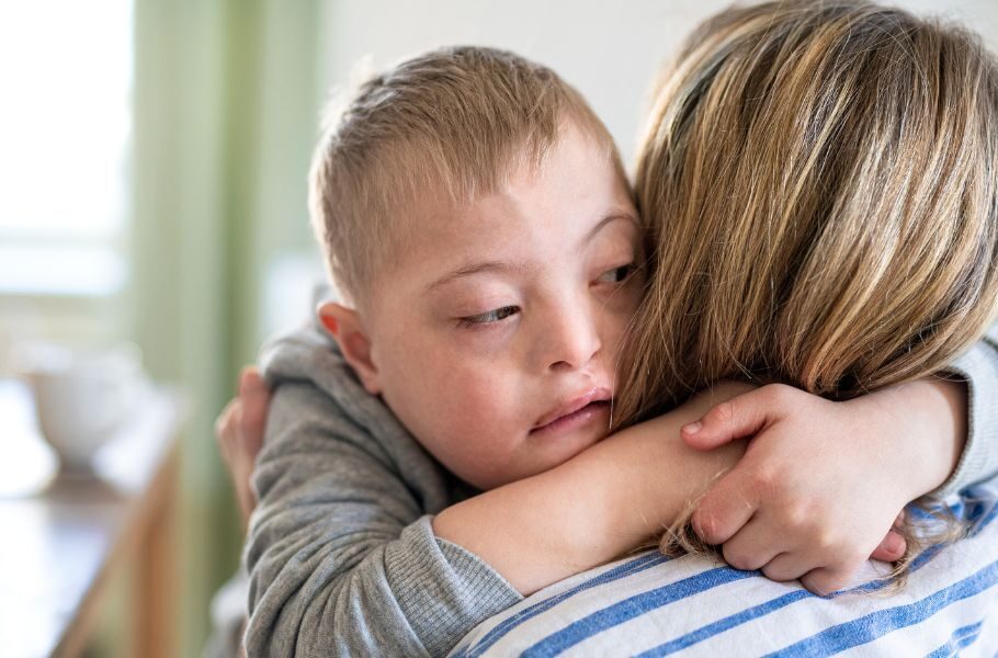 son with special needs hugging his mom