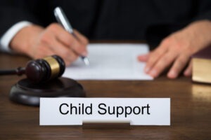 A judge behind a child support sign. Get professional help today from a Fairfax child support modifications lawyer. 