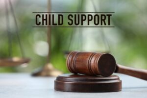 Child support above a gavel. Get professional help from a Virginia Beach child support modifications lawyer today.