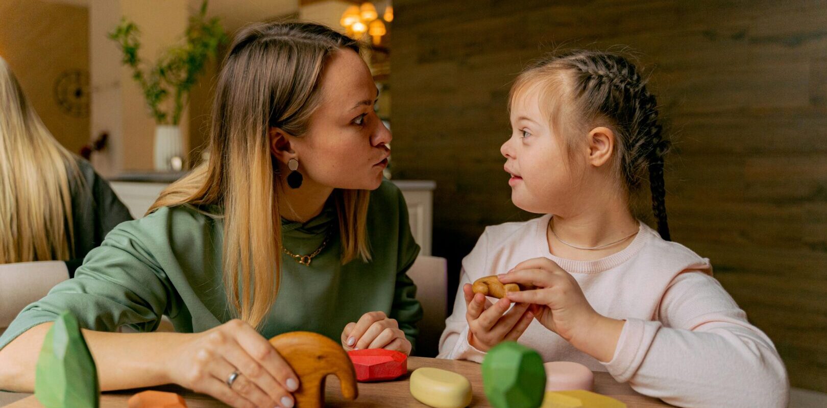 Adult woman with a special needs child playing with table top toys