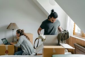 a couple in a room at daytime full of moving boxes