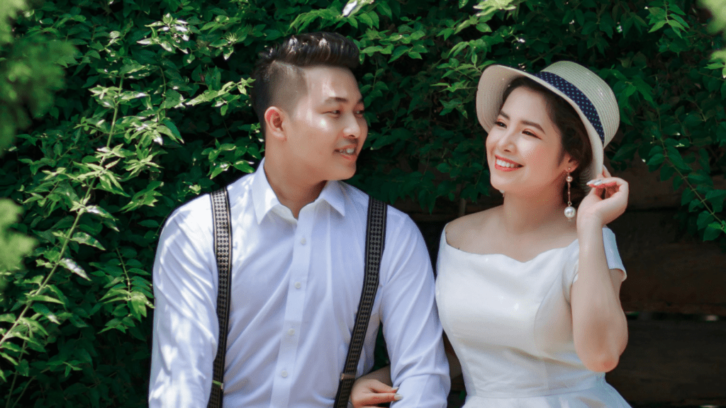 Asian couple sitting talking & smiling