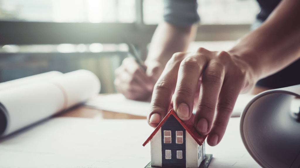 Hand on miniature house